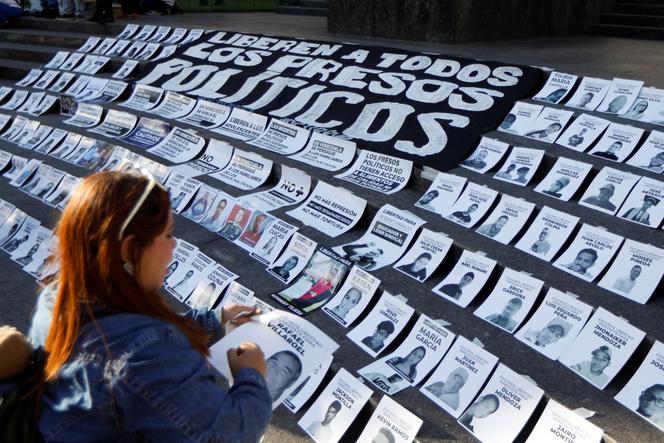 À Caracas, au Venezuela, le 14&nbsp;décembre 2025, une femme dispose des photos de prisonniers politiques lors d’une manifestation intitulée « Noël sans prisonniers politiques ».