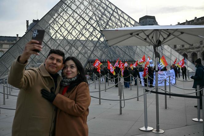 Les employés du Musée du Louvre en grève, devant l’entrée de la Grande Pyramide, à Paris, le 15 décembre 2025.