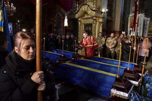Aux funérailles de six soldats ukrainiens non identifiés, à Ivano-Frankove, dans l’oblast de Lviv, en Ukraine, le 16 décembre 2025.
