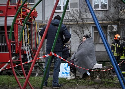 Une habitante assise près de son immeuble, touché par une frappe de drone russe, à Zaporijia, en Ukraine, le 16 décembre 2025.