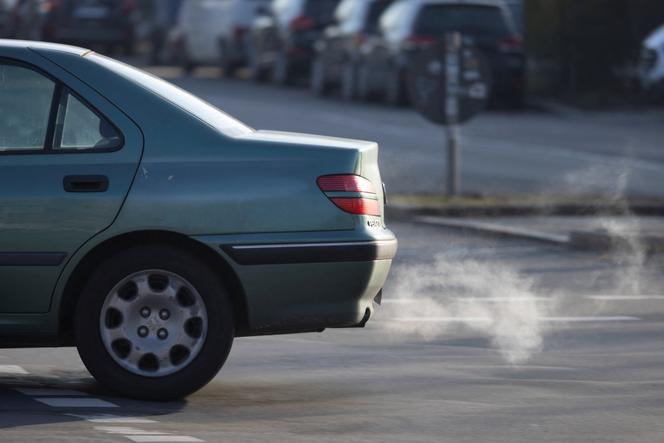 A plume of white exhaust fumes is expelled from a vehicle's tailpipe in Berlin, Germany, on December 16, 2025.