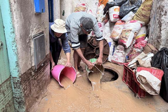 Les habitants évacuent l’eau et la boue dans la cour d’une maison, à Safi (Maroc), le 15 décembre 2025. 