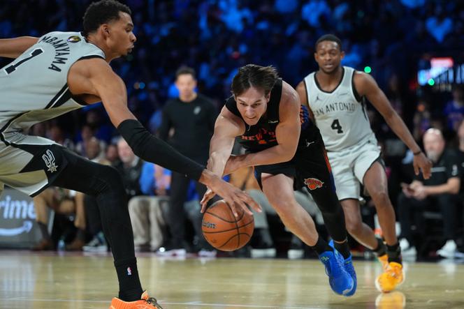 Victor Wembanyama (à gauche) essaye de stopper le joueur des New York Knicks Tyler Kolek, en finale de la Coupe NBA, à Las Vegas (Nevada), le 16 décembre 2025.