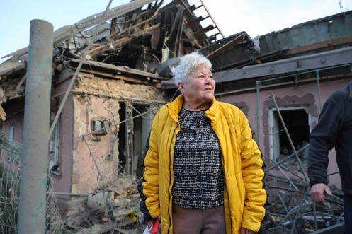 Une femme observe sa maison détruite, à Zaporijia, en Ukraine, le 19 décembre 2025.