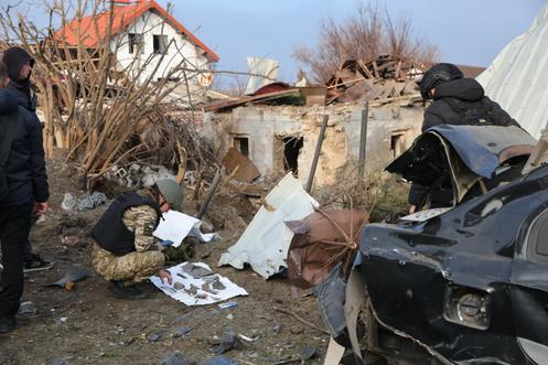 Une policière collecte les fragments d’une bombe sur le site de l’attaque, à Zaporijia, en Ukraine, le 19 décembre 2025.