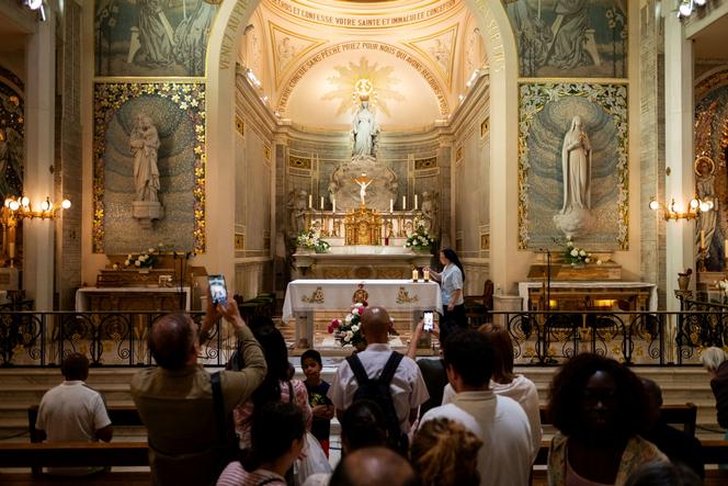 Des touristes visitant la chapelle Notre-Dame-de-la-Médaille-Miraculeuse, à Paris, le 15 juillet 2024.