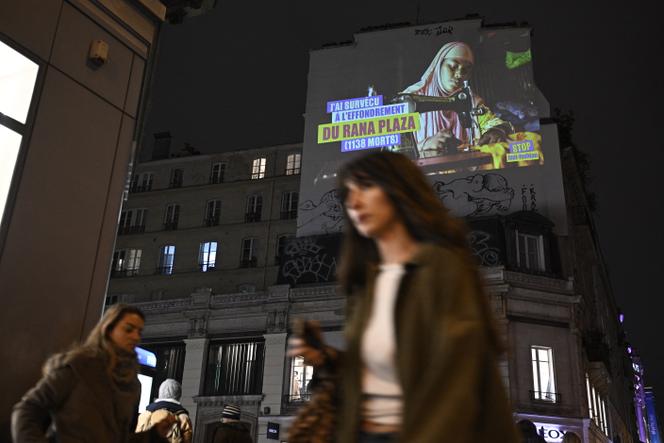 Devant un panneau d’affichage, lors d’une action menée par des militants de la coalition Stop Fast Fashion, près du BHV, à Paris, le 27&nbsp;novembre 2025.