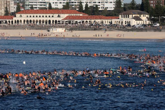 Des surfeurs se réunissent en hommage aux victimes de l’attentat de Bondi Beach, à Sydney, le 19 décembre 2025.