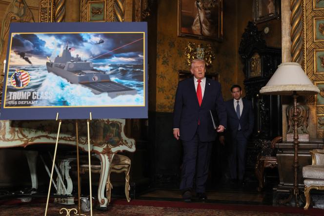 Le président américain, Donald Trump, passe devant une maquette du USS Deifant de classe Trump, avant une conférence de presse à Mar-a-lago, en Floride,  le 22 décembre 2025. 