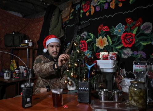 Un soldat de la 44ᵉ brigade d’artillerie indépendante d’Ukraine décore un sapin de Noël dans un abri, dans l’oblast de Dnipropetrovsk, en Ukraine, le 24 décembre 2025.