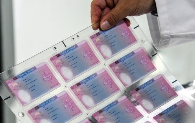 Un employé de l’Imprimerie nationale française tient une plaque de cartes d’identité imprimées, à Flers-en-Escrebieux (Nord), le 5 juillet 2019. 