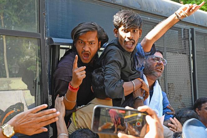 Des militants de l’organisation nationaliste hindoue Vishva Hindu Parishad, arrêtés par les forces de l’ordre, scandent des slogans depuis un véhicule de police lors d’une manifestation près du haut-commissariat du Bangladesh à Bombay, le 23&nbsp;décembre 2025.