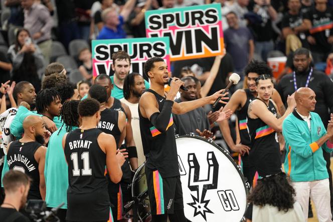 Victor Wembanyama dirige, micro en main, la célébration de la victoire des Spurs face au Thunder, à San Antonio (Texas), le 23 décembre 2025.