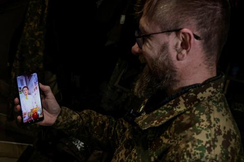 Un officier de la garde nationale ukrainienne s’entretient par visioconférence avec son fils avant le dîner de Noël, près de la ligne de front, dans l’oblast de Kharkiv, en Ukraine, le 24 décembre 2025.
