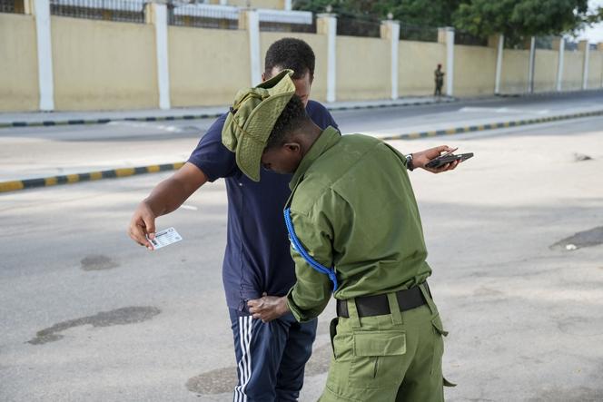 Un membre des forces de sécurité somaliennes fouille un électeur dans la rue, lors des élections municipales à Mogadiscio, le 25 décembre 2025.