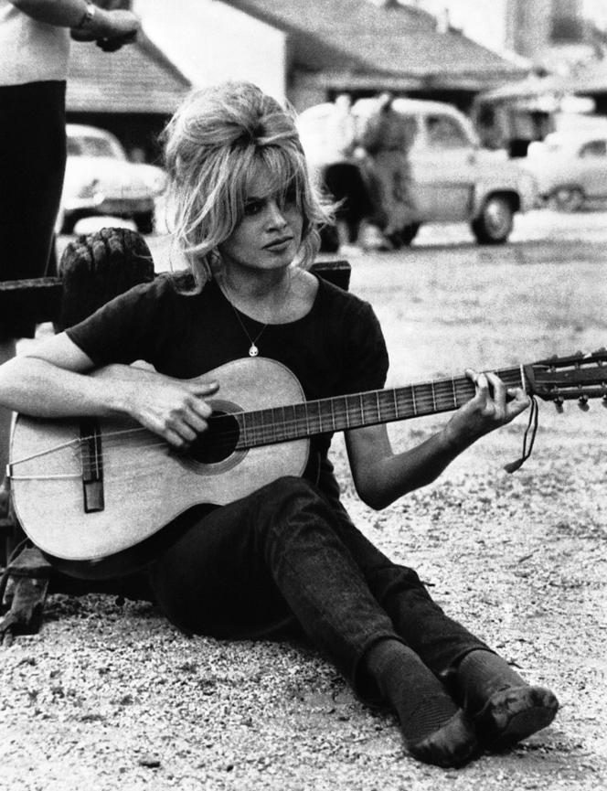 Brigitte Bardot joue de la guitare lors d’une pause sur un tournage, à Boulogne-Billancourt (Hauts-de-Seine), le 17 août 1960.