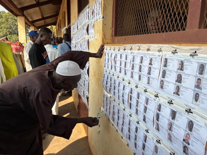 Un homme cherche son nom sur les listes électorales du bureau de vote de l’école Gbaya Dombia, dans le quartier à majorité musulmane de PK5, à Bangui, le 28 décembre 2025.