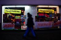 Pedestrians walk past a fireworks store in Berlin, on December 28, 2025.
