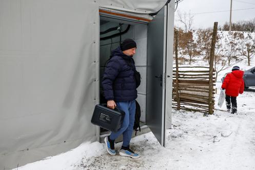 Un habitant transporte un générateur portable chargé depuis un point de ravitaillement, lors d’une longue panne de courant à Vychhorod, dans l’oblast de Kiev, le 29 décembre 2025.