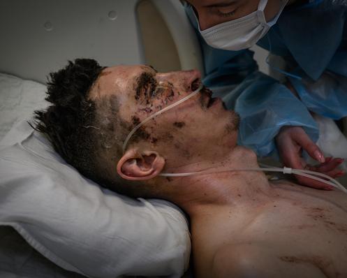 Mariian Vitalii, 35 ans, a été blessé sur la ligne de front par un tir de drone, le 5 décembre. Son épouse se penche sur son lit d’hôpital, à Dnipro, en Ukraine, le 15 décembre 2025.