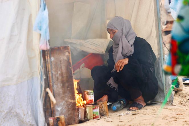 Une Palestinienne cuisine sur un feu précaire, dans une tente de fortune, alors que la région connaît des conditions hivernales rigoureuses. Au camp de réfugiés d’Al-Mawassi, dans le sud de la bande de Gaza, le 29&nbsp;décembre 2025.  