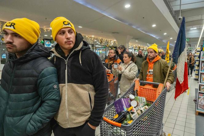 Des membres de la Coordination rurale remplissent des caddys avec des produits importés de l’étranger dans un supermarché de Carcassonne, mardi 30 décembre 2025.