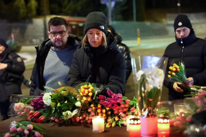 Plusieurs personnes participent à un dépôt de fleur devant le bar Le Constellation, à Crans-Montana, en Suisse, jeudi 1er janvier 2026.