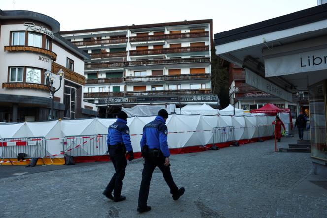 Des policiers suisses marchent devant le bar Le&nbsp;Constellation, après l’incendie et l’explosion survenus lors d’une fête du Nouvel An qui ont fait plusieurs morts et blessés, selon la police suisse, dans la station de ski huppée de Crans-Montana, dans le sud-ouest de la Suisse, le 3&nbsp;janvier 2026. 