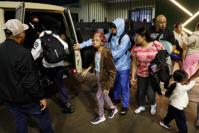 Des habitants évacuent un immeuble situé près du palais présidentiel de Miraflores après des explosions à Caracas, le 3 janvier 2026.