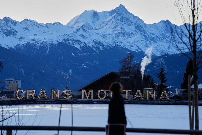 Une femme marche tôt le matin à Crans-Montana, où un incendie dévastateur dans le bar Le&nbsp;Constellation a fait des morts et des blessés pendant les célébrations du Nouvel An, dans les Alpes suisses, le 3&nbsp;janvier&nbsp;2026.