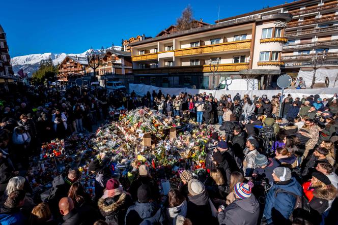 Le 4 janvier 2026, à Crans-Montana, des personnes se rassemblent autour d’un mémorial improvisé pour rendre hommage aux victimes de l’incendie qui a ravagé le bar Constellation.