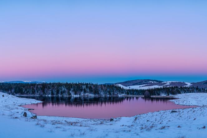 L’ombre couleur d’ardoise de la Terre bordée par la teinte rosée de la ceinture de Vénus s’élève progressivement au-dessus du lac des Pises et du massif de l’Aigoual au début de ce glacial crépuscule hivernal.