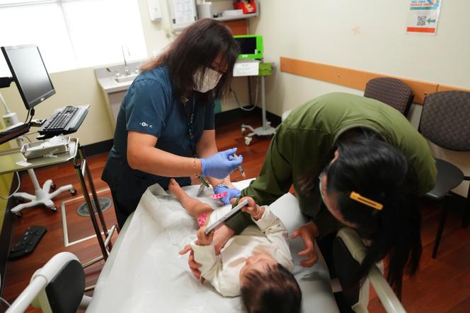 Une assistante médicale administre un vaccin à une enfant âgée de 1 an, tandis que sa mère détourne son attention, à l’International Community Health Services, à Seattle (Whashington), le 10 septembre 2025.
