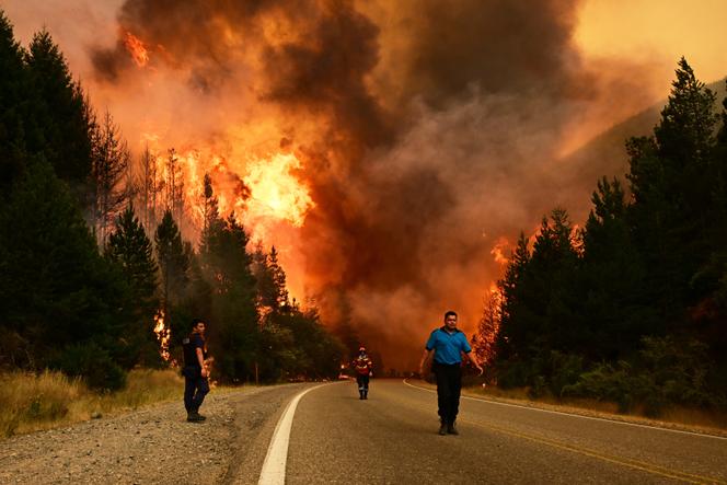 Des personnes marchent sur une route alors qu’un incendie fait rage à El Hoyo, en Patagonie argentine, le jeudi 8 janvier 2026.
