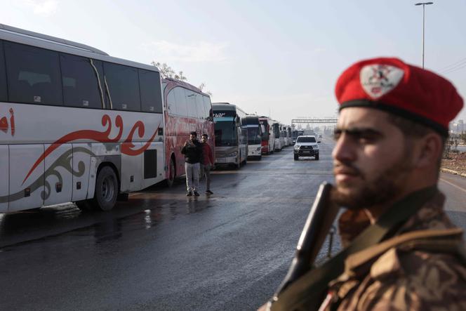 Des bus attendent pour entrer dans le quartier de Cheikh-Maqsoud afin d’évacuer les combattants des Forces démocratiques syriennes, dirigées par les Kurdes, de deux quartiers de la ville d’Alep, dans le nord de la Syrie, le 9&nbsp;janvier 2026.