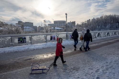 Un garçon tire une luge par une après-midi glaciale, dans le centre de Kiev, le 10 janvier 2026.