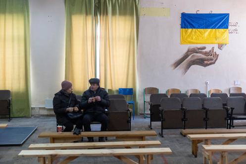 Des personnes se réchauffent dans un refuge qui offre des services de base et du chauffage pendant les coupures de courant, à Kiev, le 10 janvier 2026.