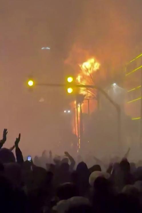 Capture vidéo prise le 14 janvier 2026 à partir d'images publiées sur les réseaux sociaux le 9 janvier 2026 qui montre des manifestants devant un bâtiment incendié à Téhéran.