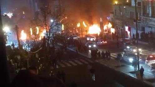 Capture vidéo prise le 14 janvier 2026 à partir d'images publiées sur les réseaux sociaux le 9 janvier 2026 qui montre des voitures incendiées lors d'une manifestation sur la place Saadat Abad, à Téhéran.