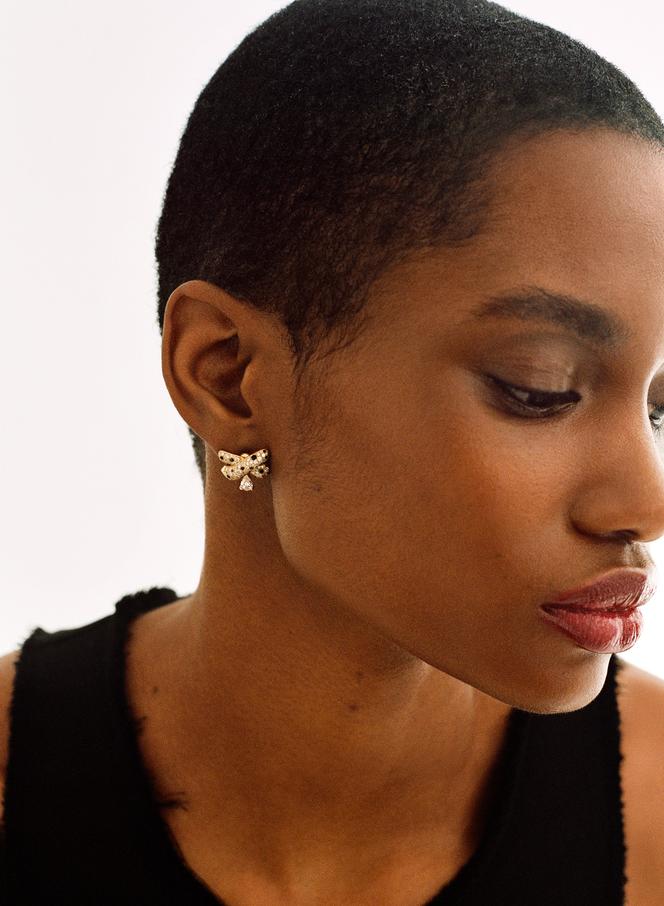 Boucle d’oreille Ombre féline, en or jaune, pavée de diamants et de spinelles noires avec un diamant taille poire, Fred, prix sur demande ; robe Rier.