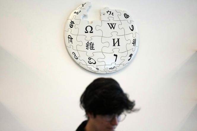 Une contributrice bénévole de Wikipédia sous le logo de l’encyclopédie en ligne, dans les bureaux de la fondation Wikimédia, à San Francisco, le 12 janvier 2026.