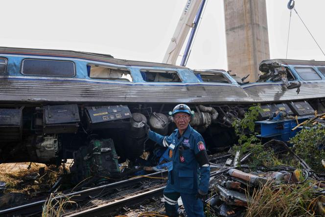 Un sauveteur se tient près de l’épave d’un train après qu’une grue de chantier est tombée dessus, dans la province de Nakhon Ratchasima, en Thaïlande, le 14 janvier 2026.