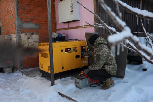 Un volontaire de l'association World Central Kitchen met en marche un générateur avant de préparer des repas pour la population lors d'une panne de courant provoquée par des frappes de missiles et de drones russes ayant touché des infrastructures civiles essentielles, à Borodianka (Ukraine), le 17 janvier 2026.