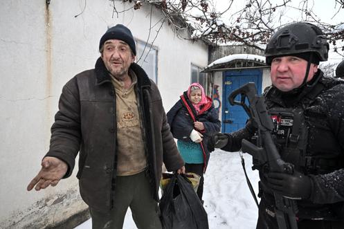 Un policier ukrainien aide les habitants à évacuer le village de Kopani, situé en première ligne, dans l’oblast de Zaporijia (Ukraine), le 16 janvier 2026.