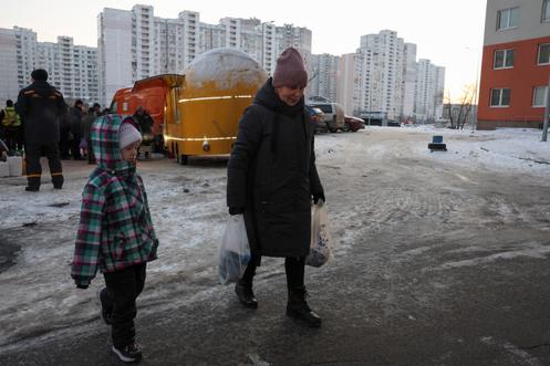 Une résidente de Borodianka repart du stand de World Central Kitchen avec des boîtes de bohrach, le 17 janvier 2026.