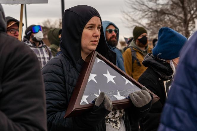 Une manifestante avec un drapeau américain en « triangle plié » en signe de deuil, à Minneapolis (Minnesota), le 15 janvier 2026.