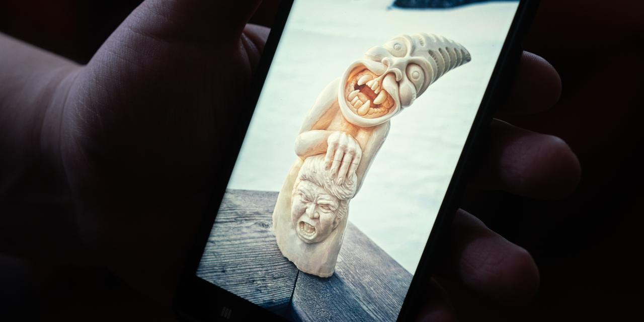 Vue aérienne du paysage enneigé du Groenland, montrant des montagnes escarpées et un fjord.