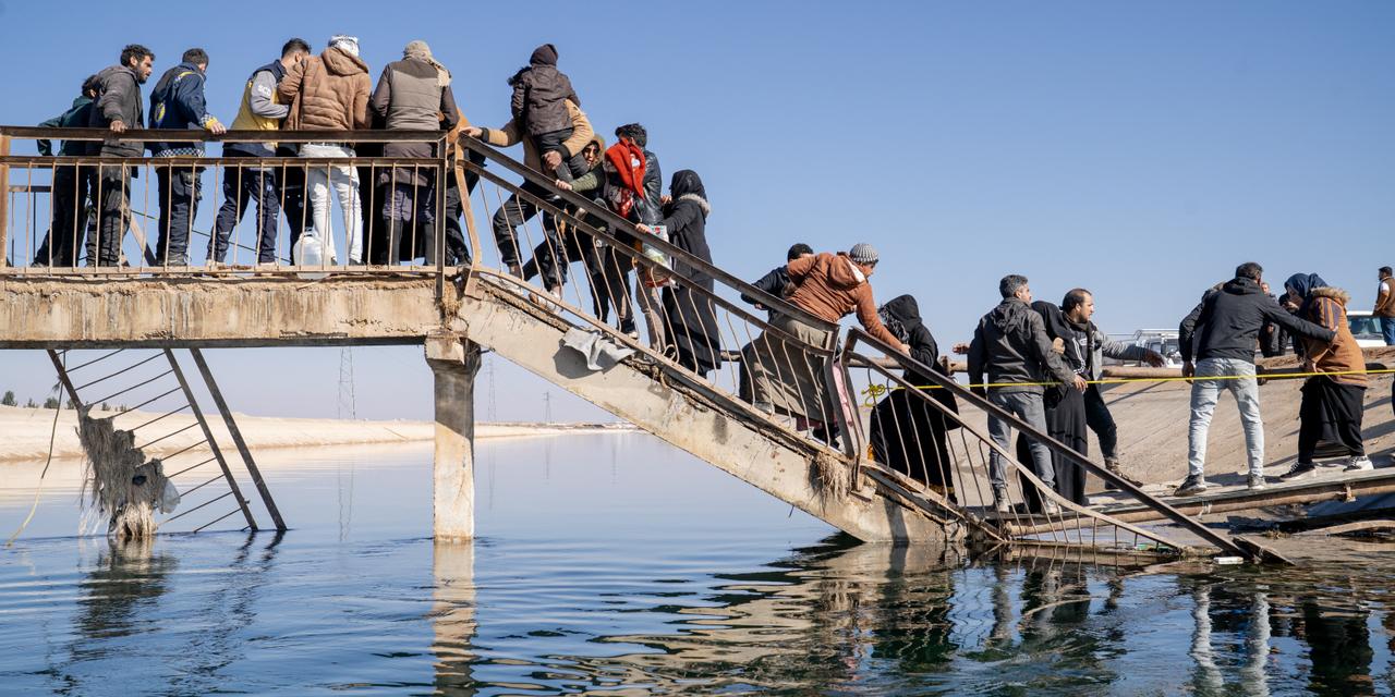 Des civils fuient les zones contrôlées par les Forces démocratiques syriennes (FDS) en traversant un pont endommagé à Rasm al-Harmal, en Syrie, le 16 janvier 2026. La route M15 reliant Deir Hafer à Alep où un couloir humanitaire a été ouvert ayant été fermée par les FDS, les civils sont contraints de trouver des itinéraires alternatifs. 
Philémon Barbier / Hors Format pour 