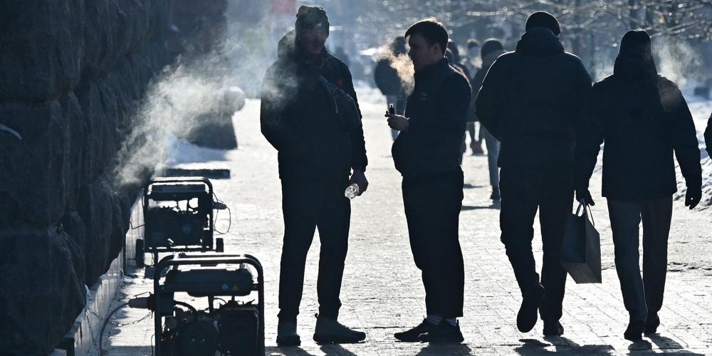 Des piétons passent devant des générateurs électriques portables installés dans le centre de Kiev, par un froid intense, le 18 janvier 2026. - SERGEI SUPINSKY/AFP
