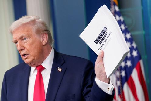 Le président américain, Donald Trump, brandit un document faisant la liste de ses accomplissements, lors d’un point presse à la Maison Blanche, à Washington, le 20 janvier 2026.